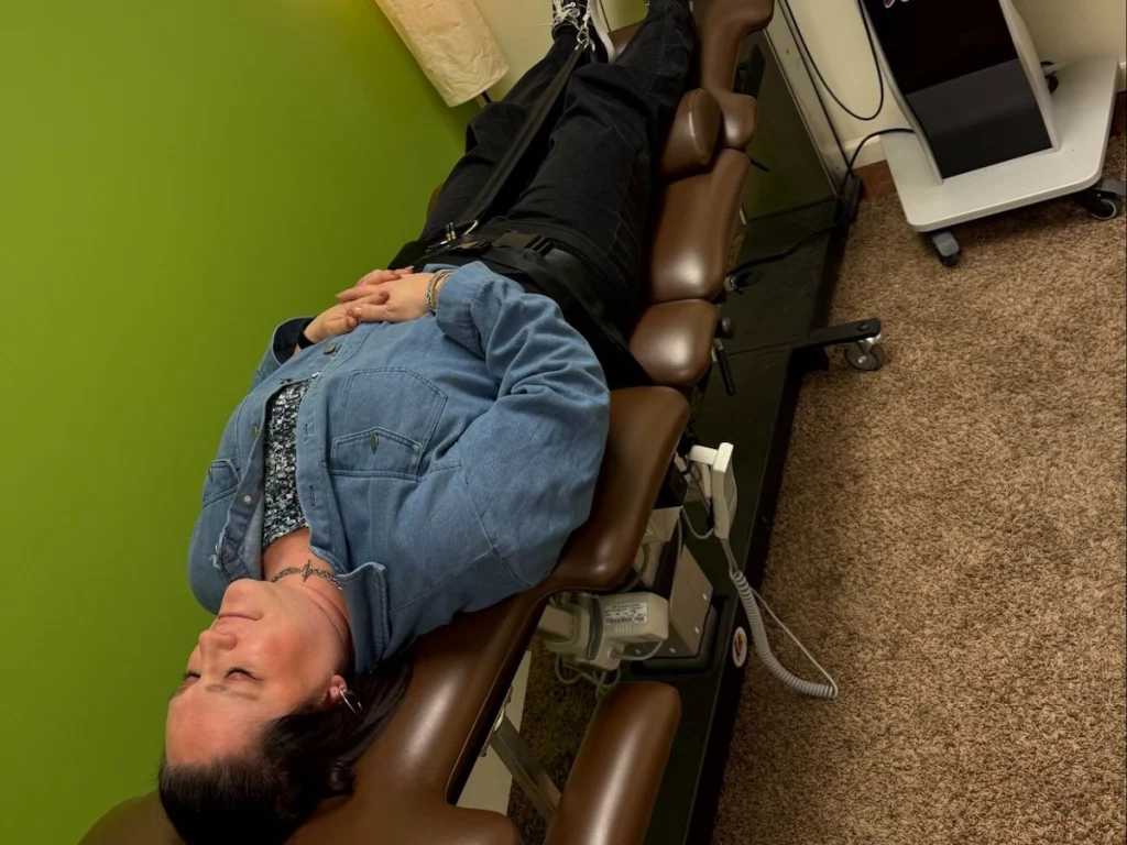 female chiropractic patient laying on a table as she receives a spinal decompression treatment at Onyx Wellness