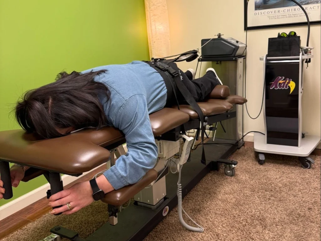 female chiropractic patient receiving decompression treatment on her lower back to ease spinal pain at Onyx Wellness